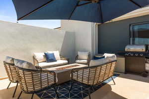 View of patio featuring an outdoor living space with a fire pit and a grill