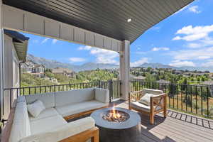 Wooden deck featuring an outdoor living space with a fire pit, a residential view, and a mountain view