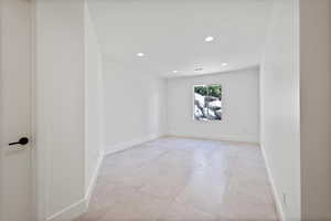 Empty room featuring recessed lighting and light tile patterned flooring