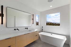Full bathroom featuring vanity, a freestanding tub, and recessed lighting