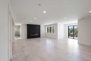 Unfurnished living room with a fireplace and recessed lighting