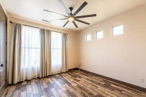 Unfurnished room with dark wood-style floors, a ceiling fan, and a textured ceiling