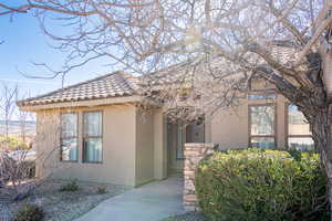 View of front of house with stucco siding and a tile roof