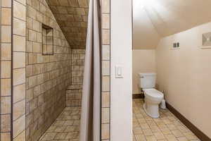 Full bath with a tile shower and light tile patterned floors