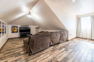 Additional living space with wood finished floors and ceiling fan