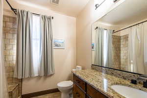 Full bathroom featuring vanity, curtained shower, and light tile patterned floors