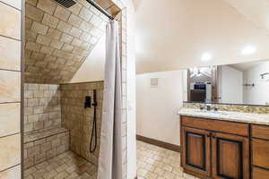 Bathroom with tiled shower and vanity