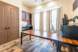 Office with light wood-type flooring, a ceiling fan, and recessed lighting