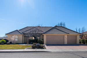 View of front of property featuring stucco siding, driveway, and a garage