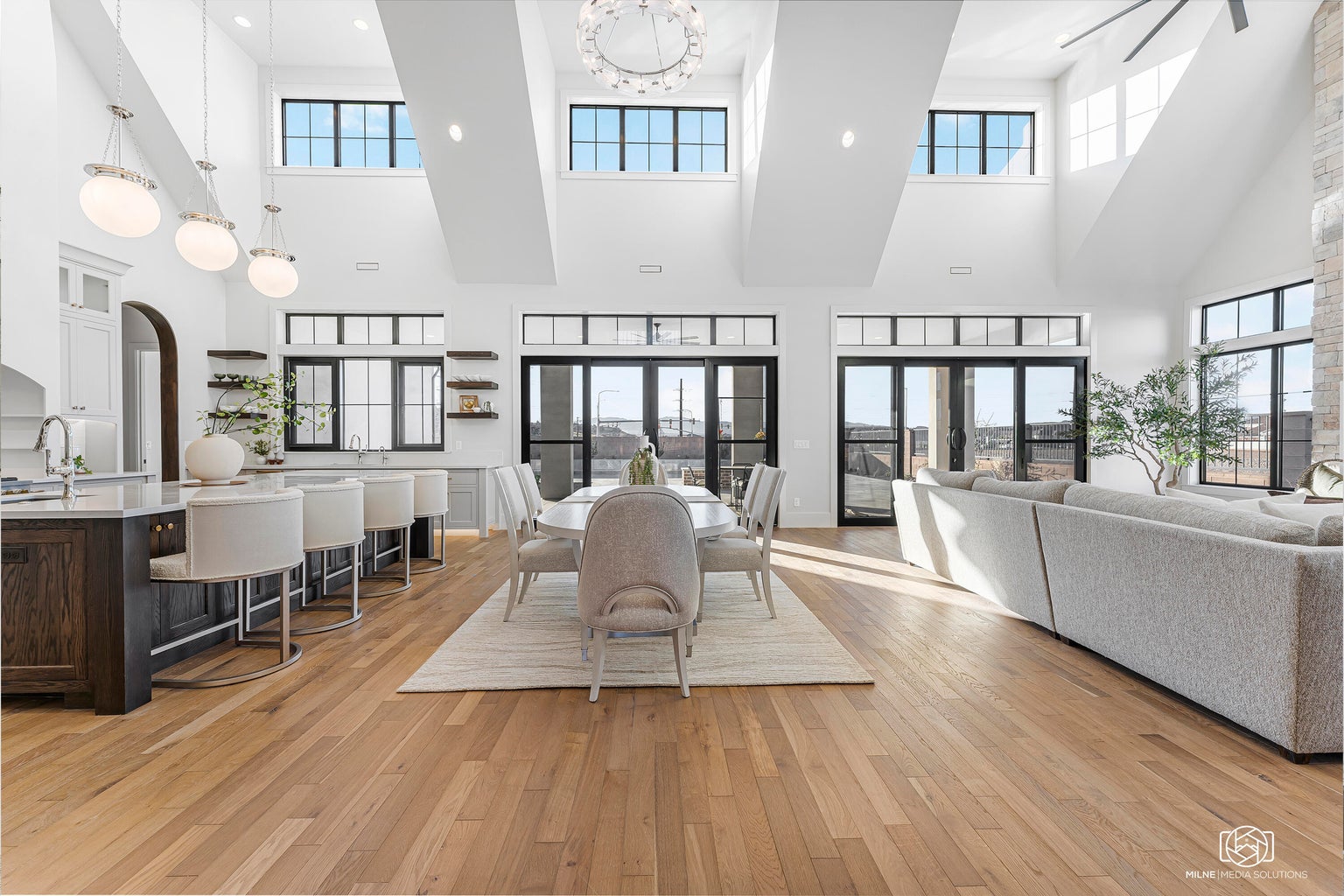 Dining area featuring light wood-style flooring, recessed lighting, and a high ceiling