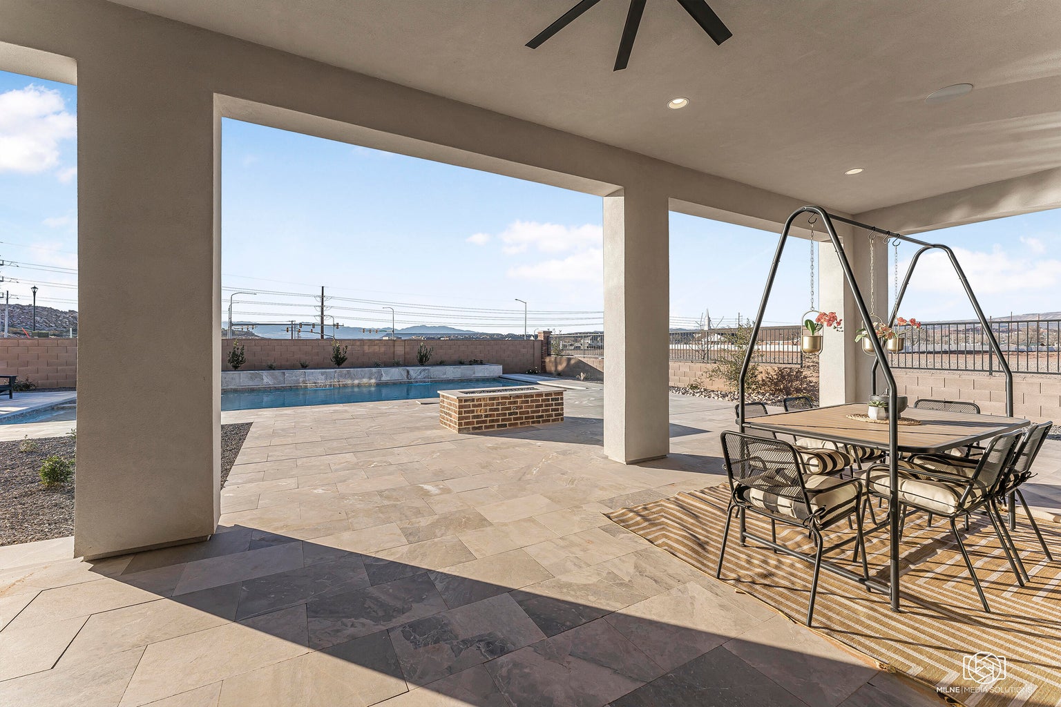 Fenced backyard featuring a patio, outdoor dining area, and a ceiling fan