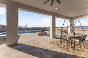 Fenced backyard featuring a patio, outdoor dining area, and a ceiling fan