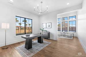 Office featuring light wood finished floors and hanging lights