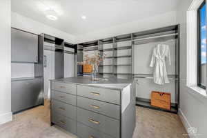 Walk in closet featuring light colored carpet