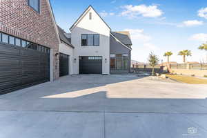 View of side of property featuring concrete driveway and stucco siding