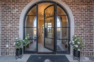 View of exterior entry featuring brick siding