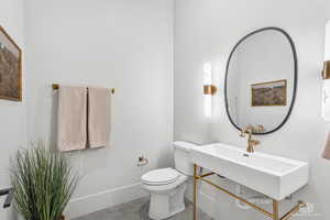 Half bath with toilet and baseboards