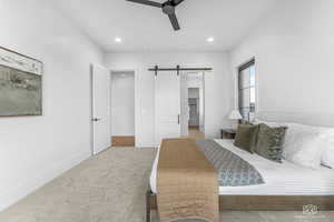 Bedroom with a barn door, a walk in closet, carpet floors, ceiling fan, and recessed lighting