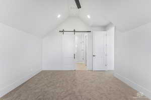 Additional living space with a barn door and light carpet