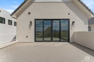 Rear view of house featuring a patio, stucco siding, and french doors