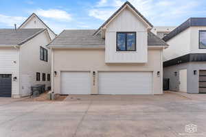 Modern inspired farmhouse featuring board and batten siding, driveway, a garage, and stucco siding