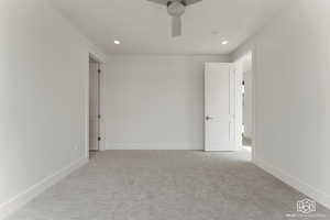 Empty room with light carpet, a ceiling fan, and recessed lighting