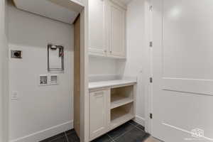 Laundry room with washer hookup and dark tile patterned floors
