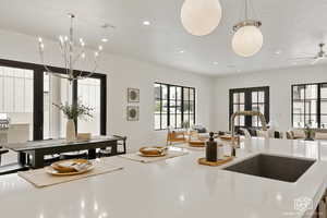 Kitchen featuring light stone counters, open floor plan, and suspended lighting