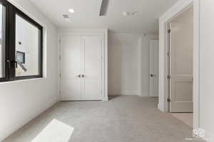 Unfurnished bedroom with light colored carpet, recessed lighting, and a closet