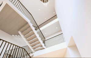 Staircase with a high ceiling and a chandelier