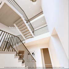 Stairs featuring a high ceiling and recessed lighting