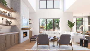Living area featuring light wood-style floors, a large fireplace, and a high ceiling