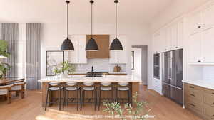 Kitchen with dual tone cabinets, light stone countertops, stainless steel appliances, decorative light fixtures, and light wood-style floors