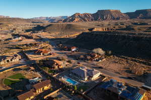 Aerial view of property and surrounding area featuring a mountain backdrop and nearby suburban area