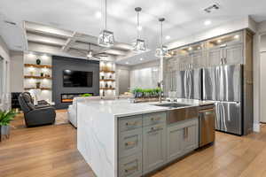 Kitchen featuring ceiling fan, gray cabinets, light wood-style flooring, built in features, and coffered ceiling