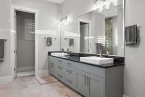 Full bath featuring double vanity and a stall shower