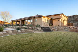 Rear view of property featuring a patio area, stucco siding, a yard, and a tile roof