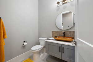 Bathroom featuring vanity and decorative backsplash