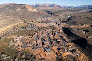 Aerial overview of property's location with a mountainous background and nearby suburban area