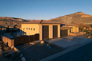 View of front of house featuring a mountain view, a gate, stucco siding, a tiled roof, and driveway