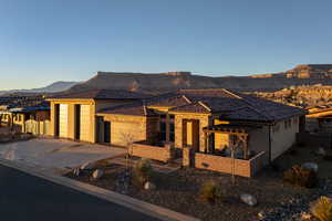 View of front of home with a mountain view, a garage, concrete driveway, stone siding, and a pergola