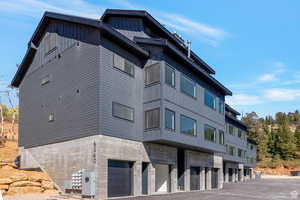 View of apartment building / complex with an attached garage and driveway