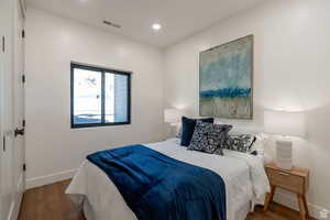 Bedroom with wood finished floors and recessed lighting