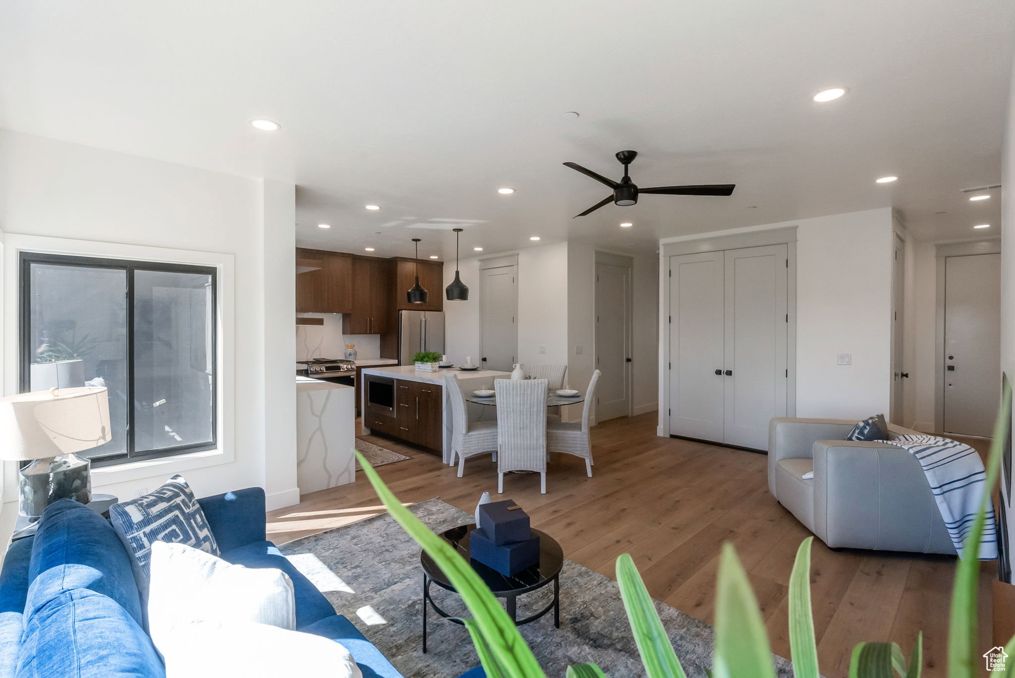 Living room featuring light wood-style flooring, a ceiling fan, and recessed lighting