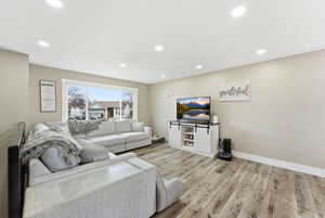 Living area featuring light wood finished floors and recessed lighting