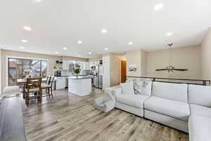 Living room featuring light wood-style flooring, recessed lighting, and a ceiling fan