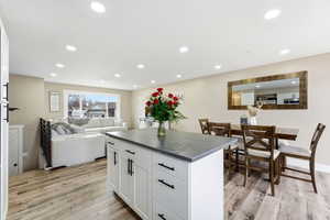 Kitchen featuring dark countertops, white cabinetry, light wood-style floors, open floor plan, and recessed lighting