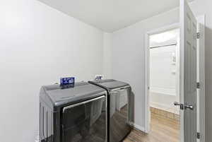 Laundry area with wood tiled floors and washing machine and clothes dryer
