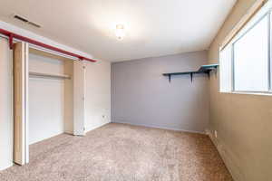 Unfurnished bedroom featuring a closet and light colored carpet