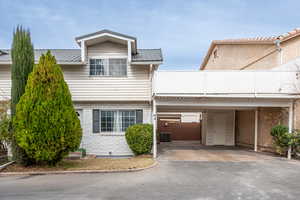 View of front facade featuring a metal roof and a carport